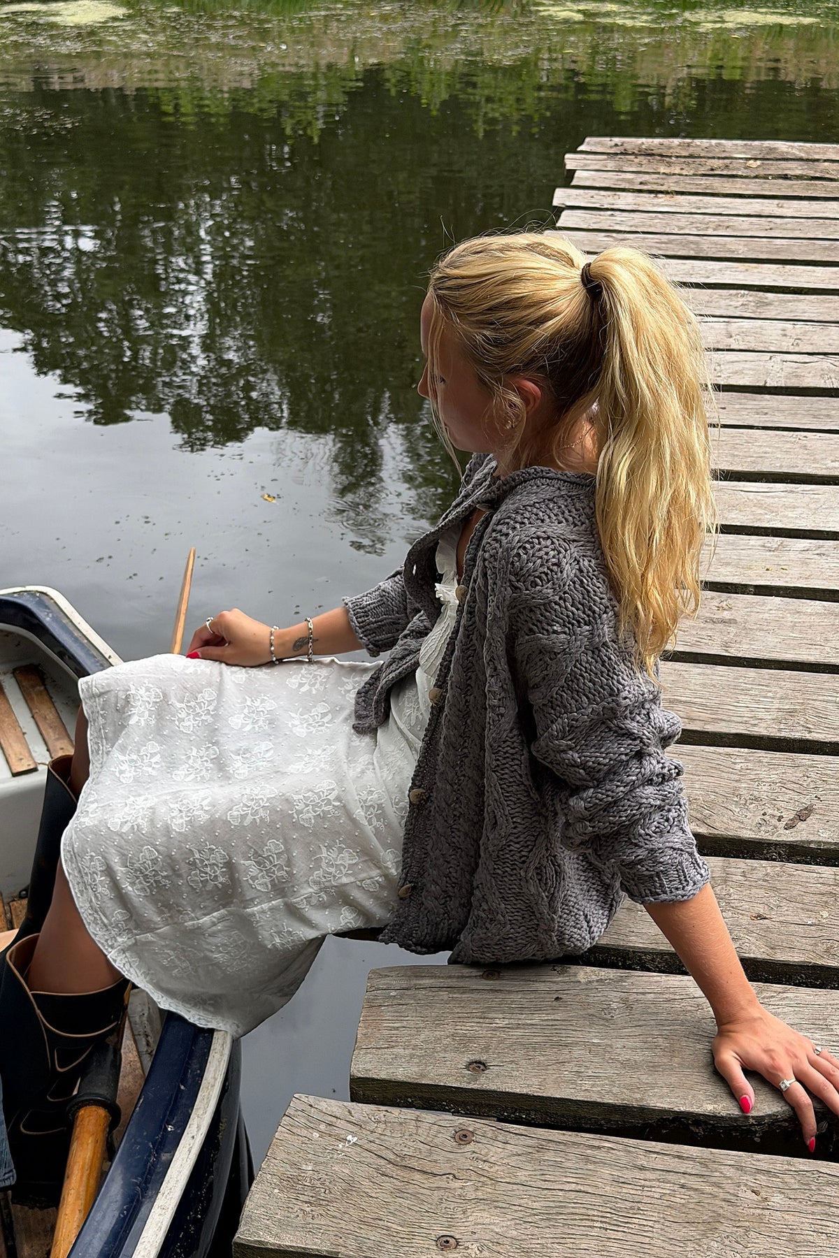 Free People Opal Cable Knit Cardigan in Steel Grey styled outdoors by the water