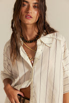 Close-up of the Free People Seaside Cotton Stripe Shirt in Ivory Combo worn open over a white top