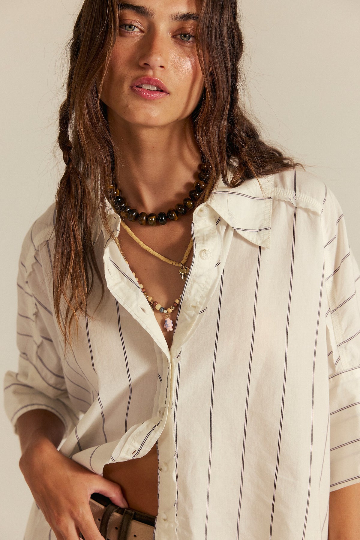 Close-up of the Free People Seaside Cotton Stripe Shirt in Ivory Combo worn open over a white top