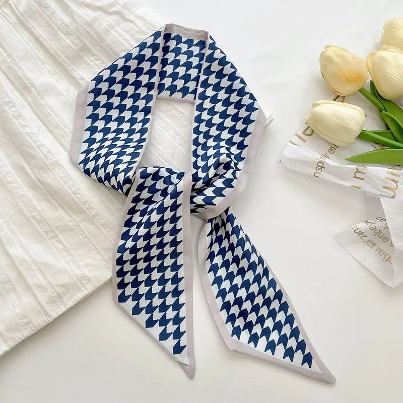 Blue and white patterned scarf on a white surface with tulips