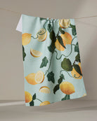 Geometry Amalfi Lemons tea towel laid flat with a bright lemon print