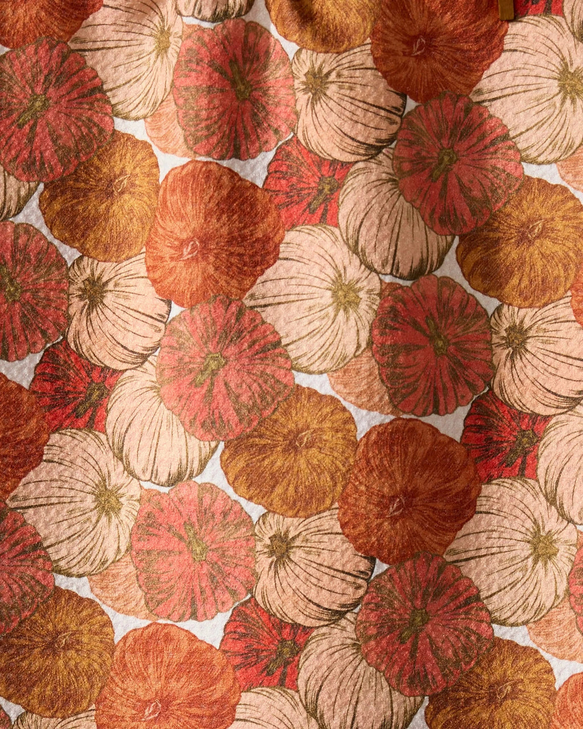 Close-up of the Geometry Tendril tea towel painterly pumpkin print in coral, rust, cream and gold