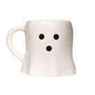 A white ceramic mug shaped like a ghost with a simple black face made of two dots on the upper front and one dot below, shown on a plain white background.