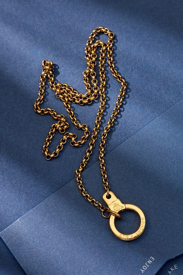 Gold chain necklace on a blue textured background