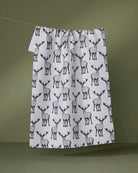 Hartley tea towel in soft white with black stag print hanging on a line