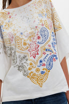 White t-shirt with colorful paisley pattern worn by a person