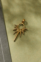 Gold star-shaped pendant on a green surface