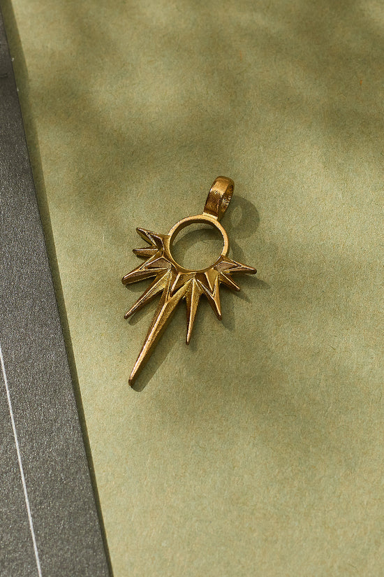 Gold star-shaped pendant on a green surface