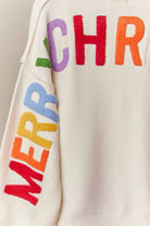 Close-up of the rainbow Merry Christmas letters on the back of the ivory cardigan
