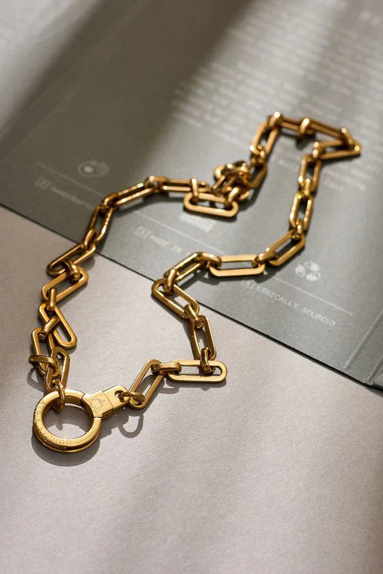 Gold chain necklace on a metallic surface