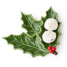Holly sprig ceramic dessert plate holding two powdered snowball cookies