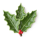 Holly sprig shaped ceramic dessert plate with glossy green leaves and red berries on a white background