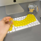 Kikkerland cleaning putty lifting dust from a computer keyboard