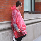 Kikkerland emergency rain poncho in red worn outdoors