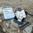 Kikkerland Fisherman grooming kit tin open on a rock