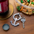 Kikkerland anchor multi-tool used as a bottle opener on a table