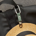 Kikkerland travel hat clip holding a straw hat on a bag