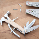Kikkerland wood hammer multi-tool on a workbench with nails and tools