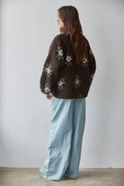 Back view of chocolate brown floral sherpa fleece jacket with light blue trim