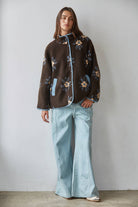 Knit sherpa fleece floral print button down jacket in chocolate brown, full length front view styled with light wash wide leg jeans