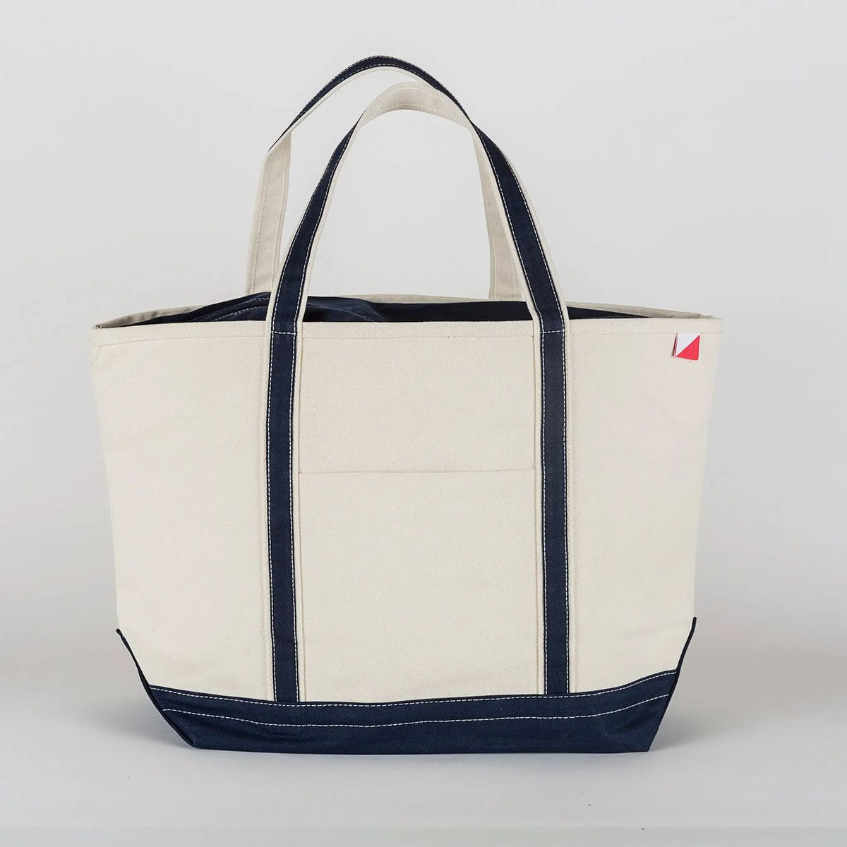 Beige tote bag with navy accents on a light gray background