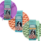 BarkBistro Buddy Budder enrichment mats in purple, orange, and turquoise with packaging on a white background.