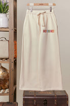 Front of the cream Merry Christmas wide-leg sweatpants with drawstring waist and small multicolor Ho Ho Ho detail