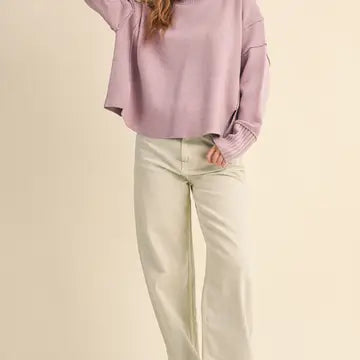 Full-length front view of the &merci Mock Neck Ribbed Sweater in lavender styled with cream wide-leg jeans