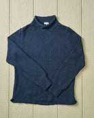 Blue rollneck sweater on a wooden surface