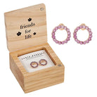 Pink hoop earrings in a wooden box with 'friends for life' text
