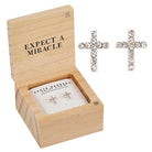 Wooden box with 'Expect a Miracle' text, containing cross-shaped earrings.