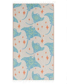 A rectangular beach towel with fringed edges, featuring a pattern of blue stingrays and orange diamond shapes on a light beige background.