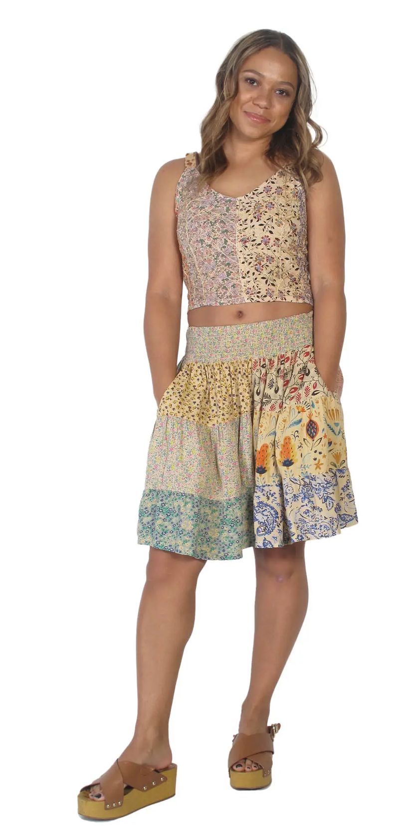 Woman wearing a patterned sleeveless top and skirt on a white background