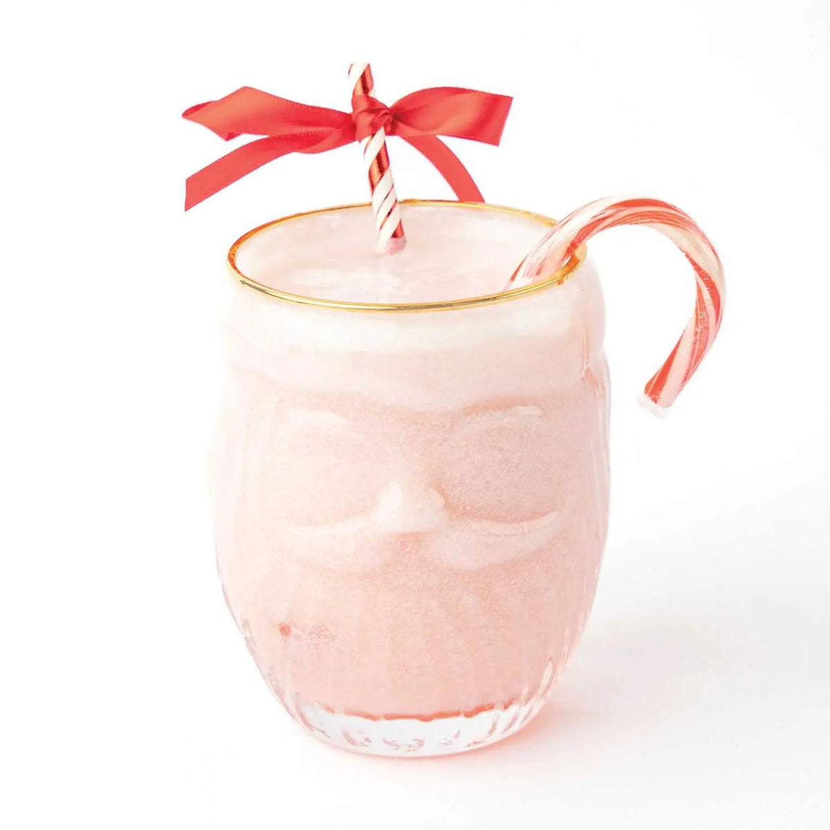Embossed Santa face drinking glass with a gold rim, filled with a pink peppermint drink and a candy cane with a red bow