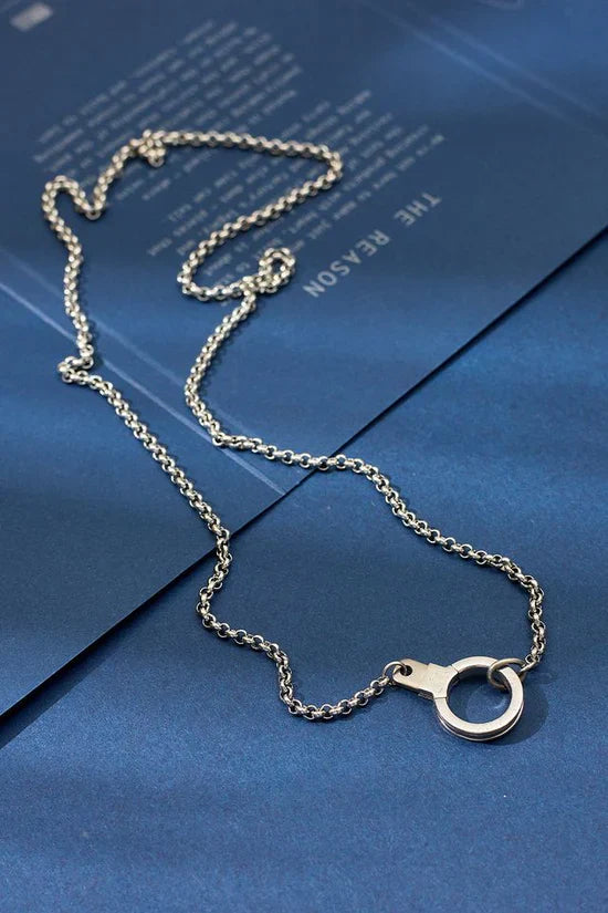 Silver chain necklace on a blue surface