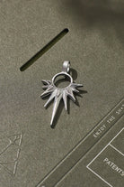Silver pendant on a textured green surface
