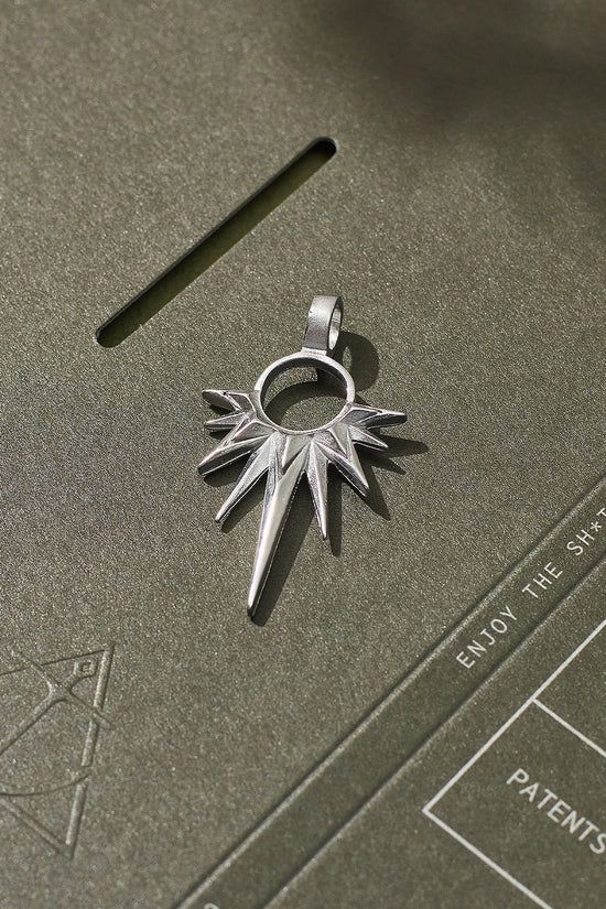 Silver pendant on a textured green surface