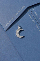 Silver crescent moon pendant on a blue card with motivational text