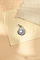 Silver pendant on a beige fabric background