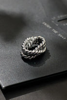 Silver braided ring on a black surface