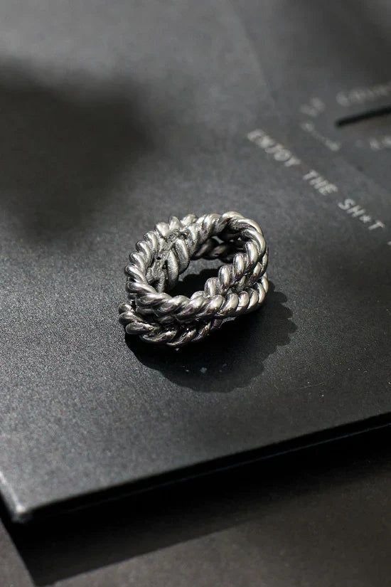 Silver braided ring on a black surface