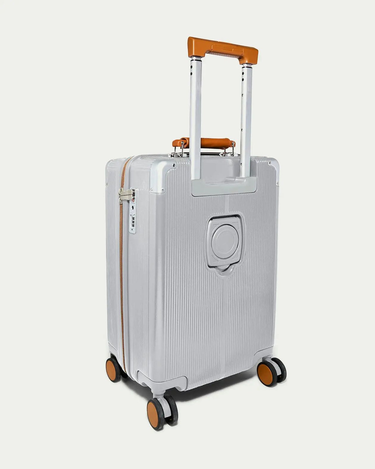 Silver suitcase with brown handle and wheels on a light gray background