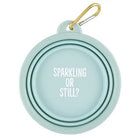 Light blue carabiner with 'Sparkling or Still?' text and gold carabiner clip on white background