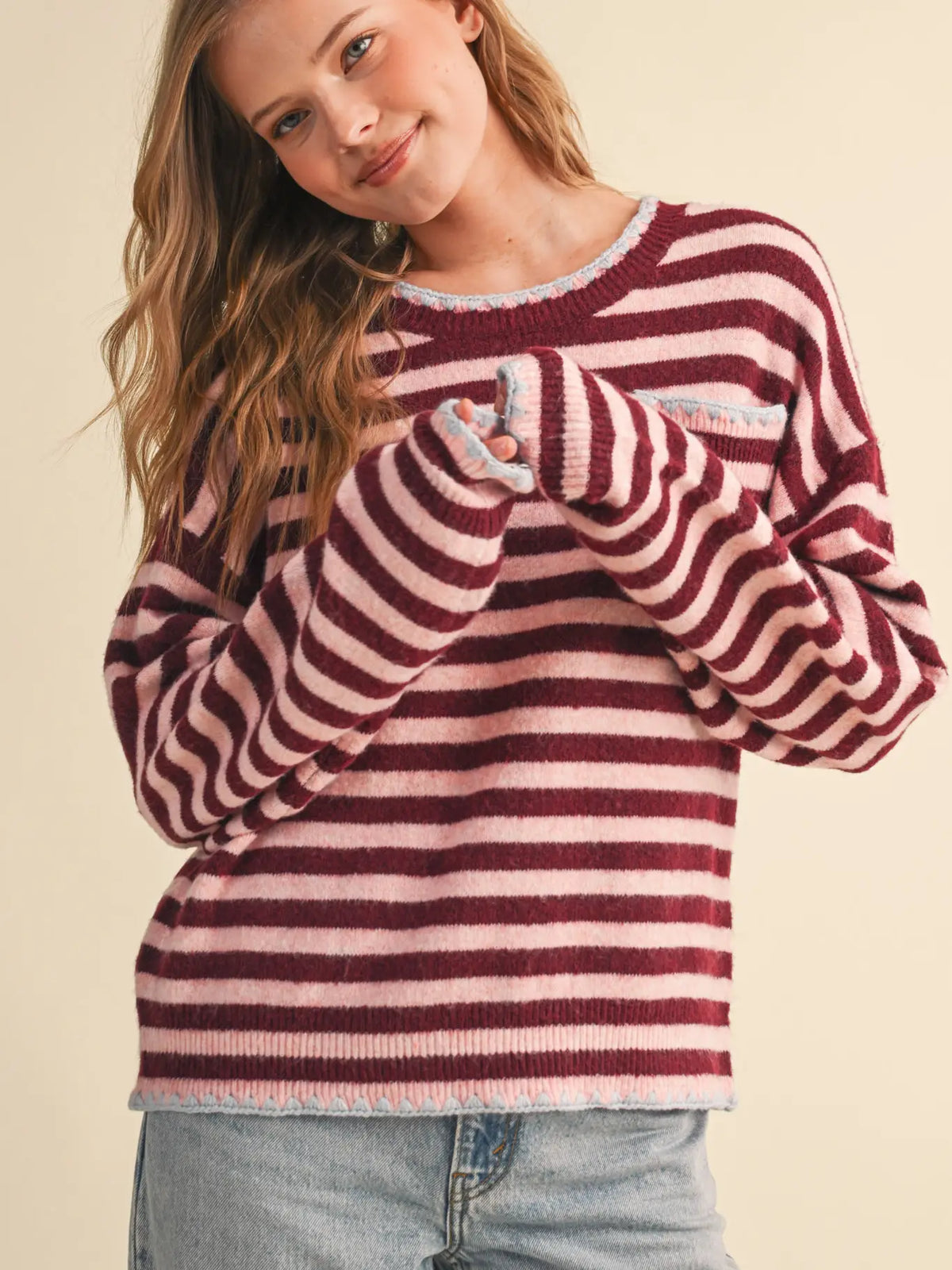 Full-length view of the &merci Striped Pocket Sweater in wine and pink styled with light-wash jeans