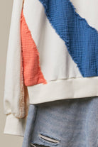 Close-up of the Sun Patchwork Sweatshirt showing cobalt blue and ivory mixed-fabric panels