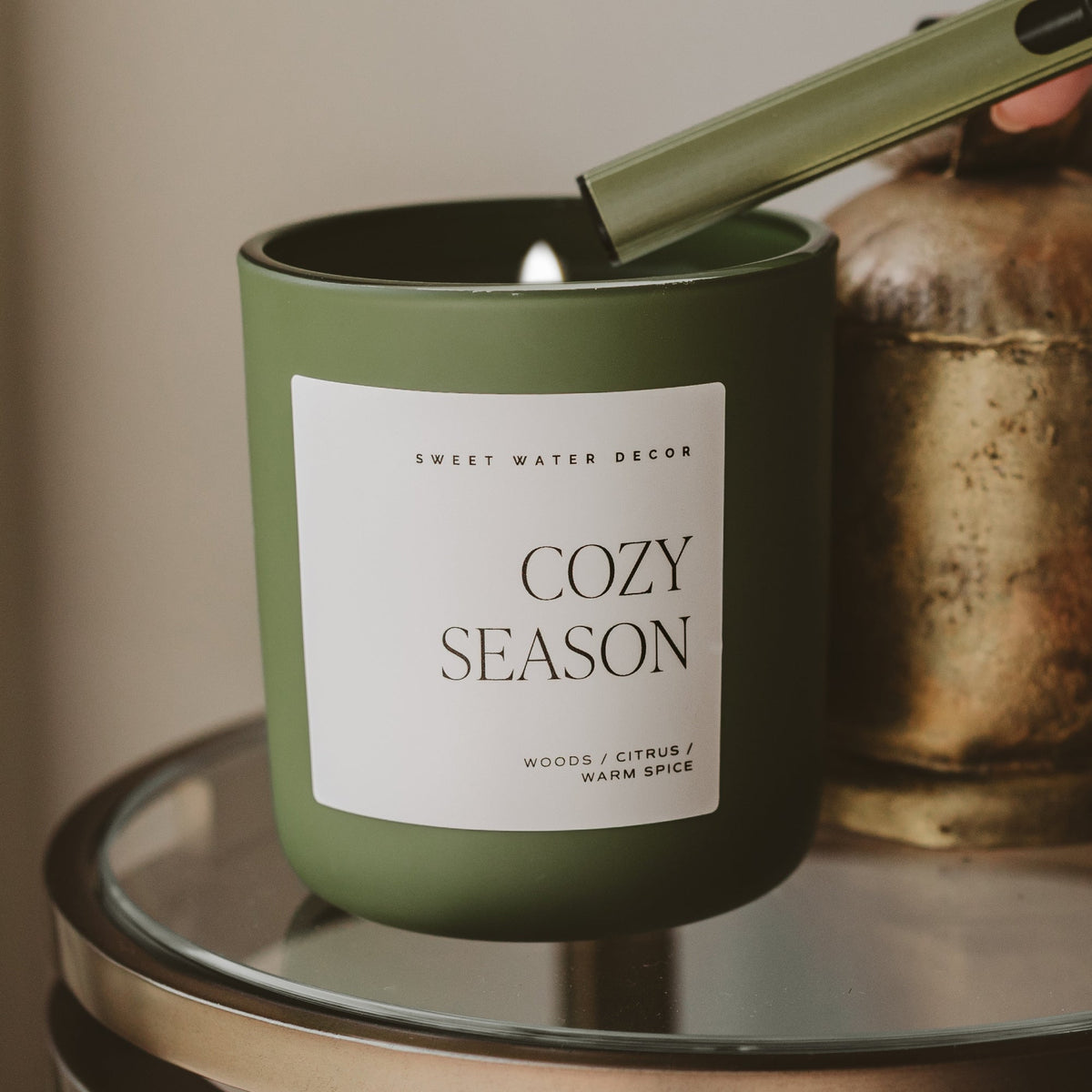 Lit Cozy Season 15 oz soy candle in an olive green matte jar styled for fall
