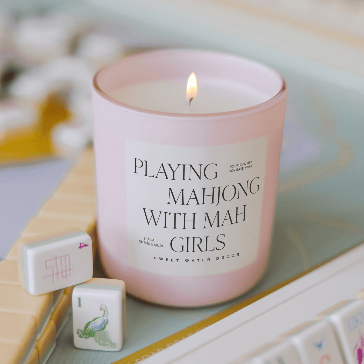 Playing Mahjong With Mah Girls 15 oz soy candle in a pink matte jar styled with mahjong tiles