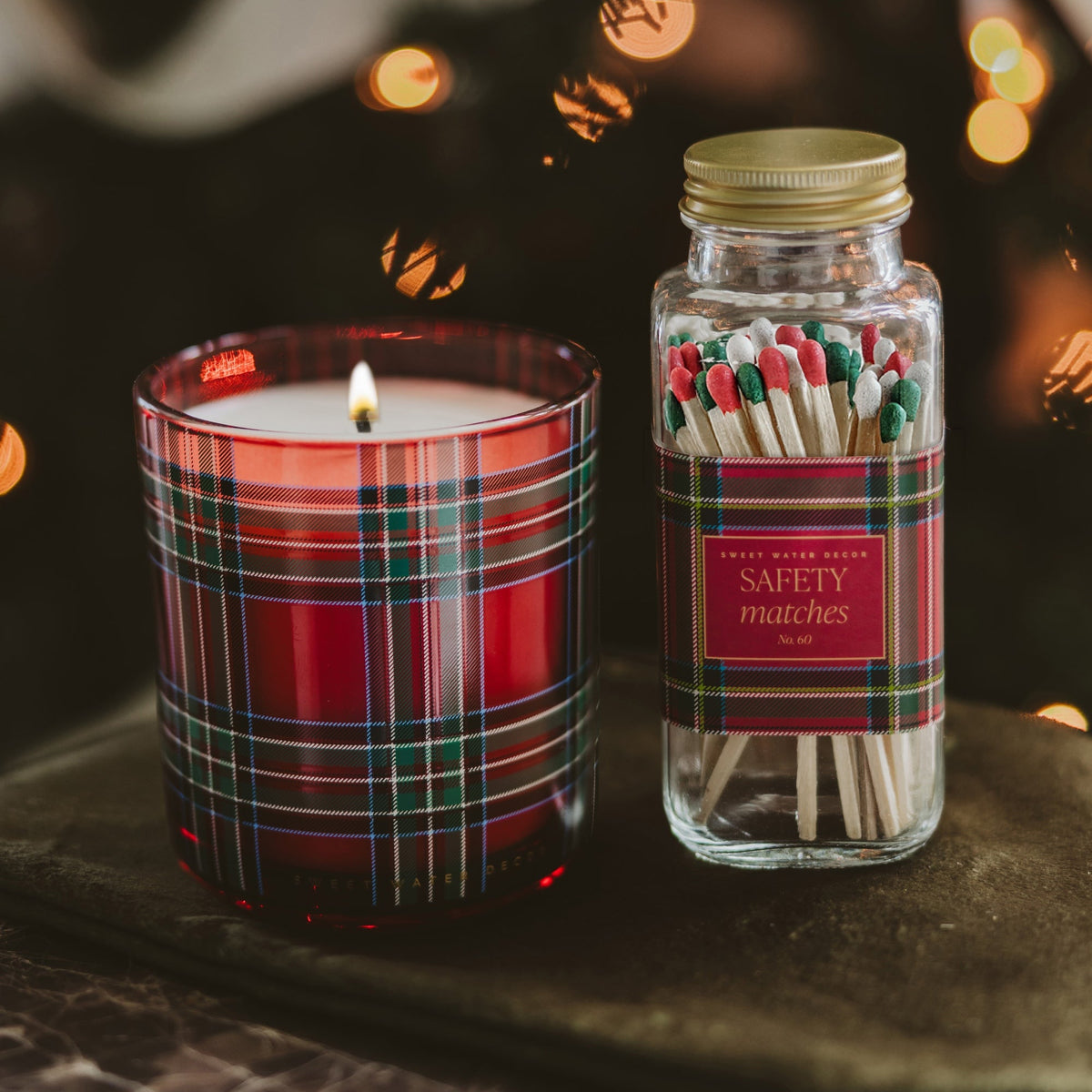 Lit Warm and Cozy red plaid candle styled as a Christmas gift