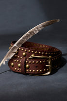 Cognac leather Sola Stud Belt coiled to show the rounded studs and brass buckle