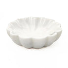 White marble flower-shaped trinket dish with scalloped petal edges on a white background
